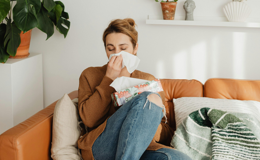woman on couch with seasonal allergies, pet dander, allergens